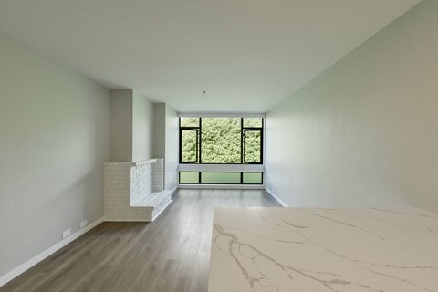 a living room with a large window and a marble table