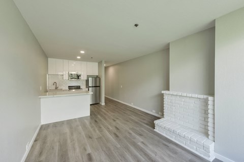 a living room with a fireplace and a kitchen