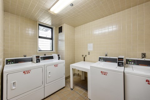a laundry room with four washes and three washing machines