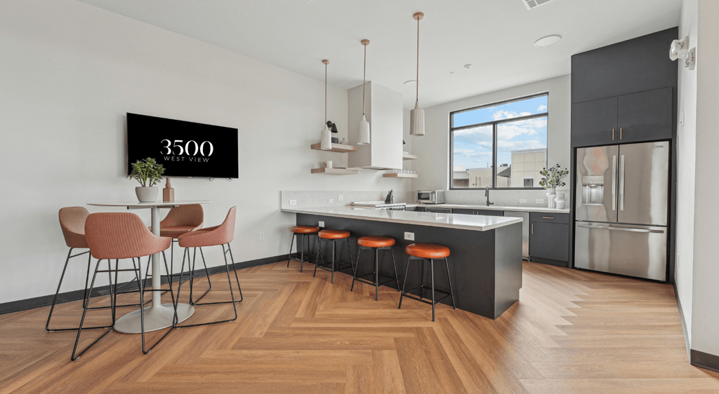 A modern kitchen with a bar area and a dining table set up.