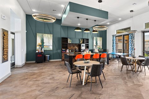 a dining room with tables and chairs and a kitchen