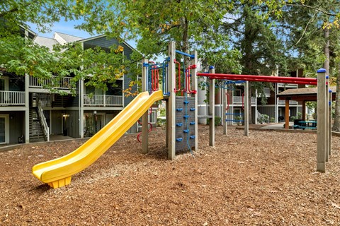 Playground with a yellow slide and red and blue slides at Canyon Creek, OR, 97070