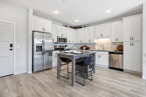 a kitchen with white cabinets and stainless steel appliances