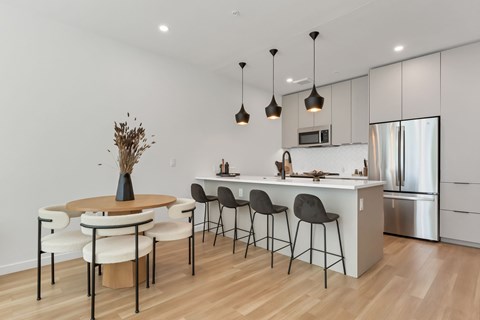 A modern kitchen with a dining table and chairs.