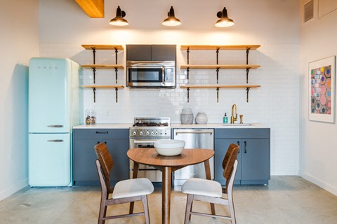 a kitchen with blue cabinets and a table and chairs