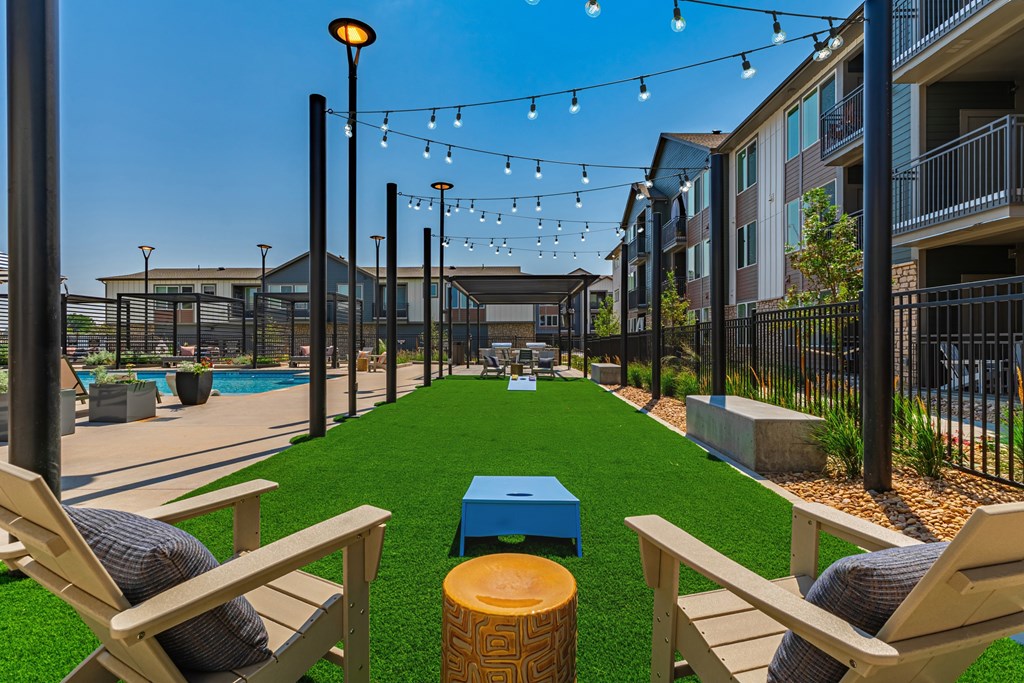 A sunny day at the outdoor pool area with lounge chairs and string lights.