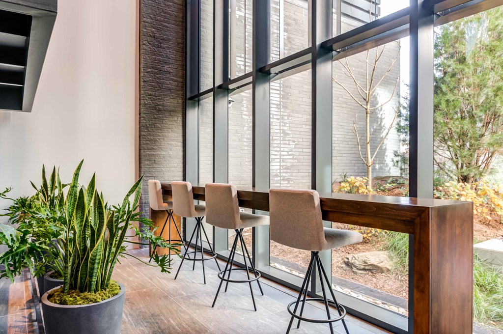 a dining area with a table and chairs and large windows