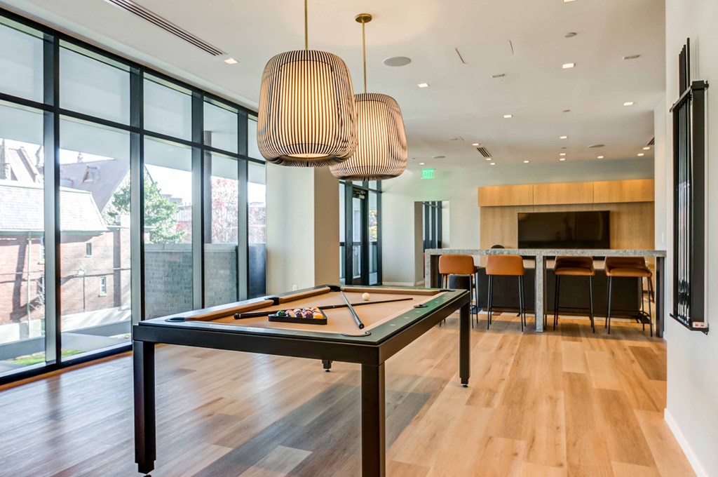 a billiards table in a living room with a kitchen