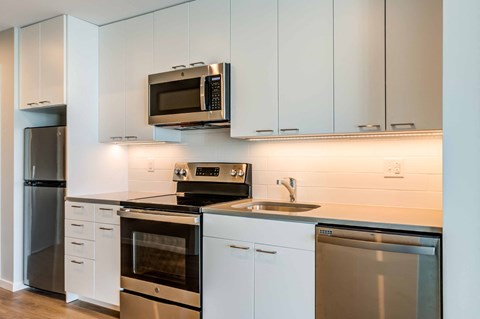 a kitchen with stainless steel appliances and white cabinets