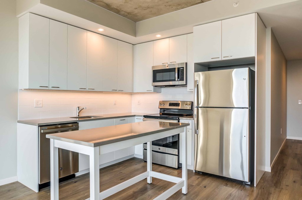 a modern kitchen with stainless steel appliances and white cabinets