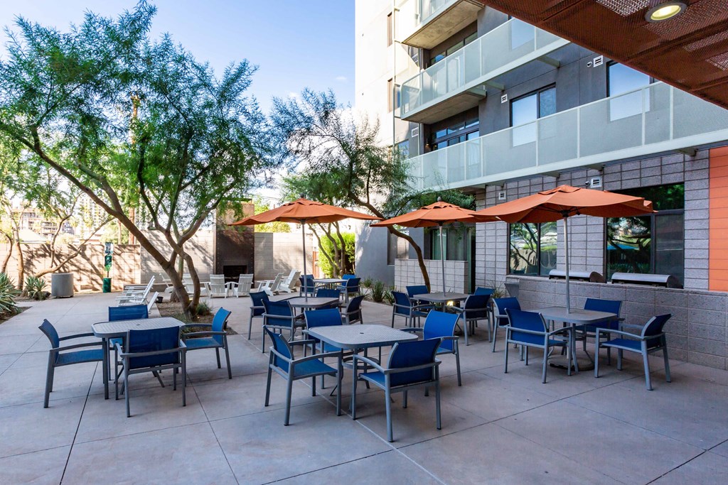 a patio with tables and chairs and umbrellas