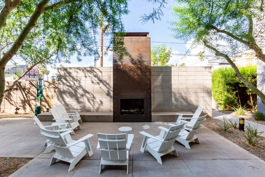 a group of white chairs sitting in front of a fireplace