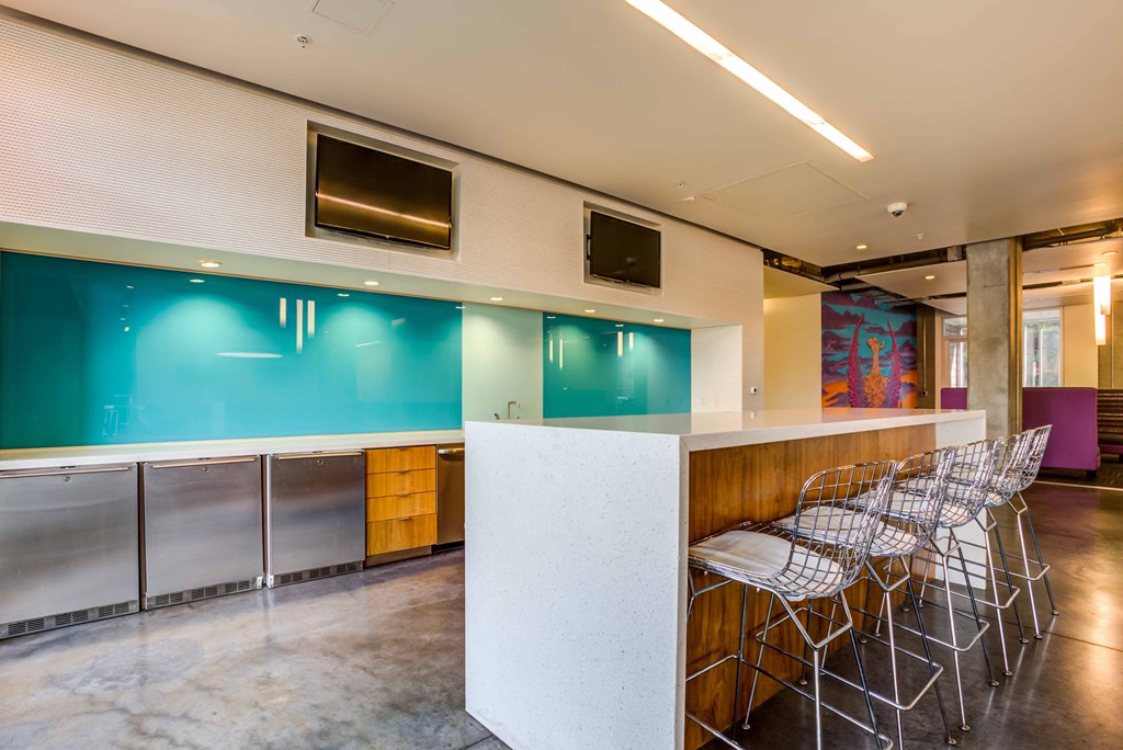 a bar with chairs in a room with a counter