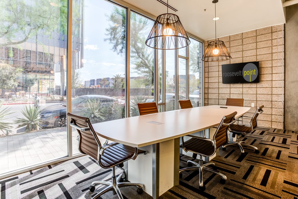 a conference room with a large window and a table with chairs