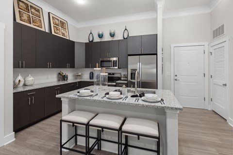 A kitchen with a table set for two and a white fridge.