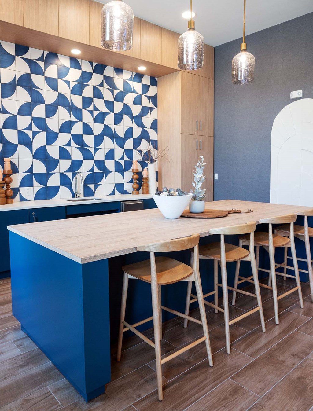 a blue kitchen with a long wooden table and chairs