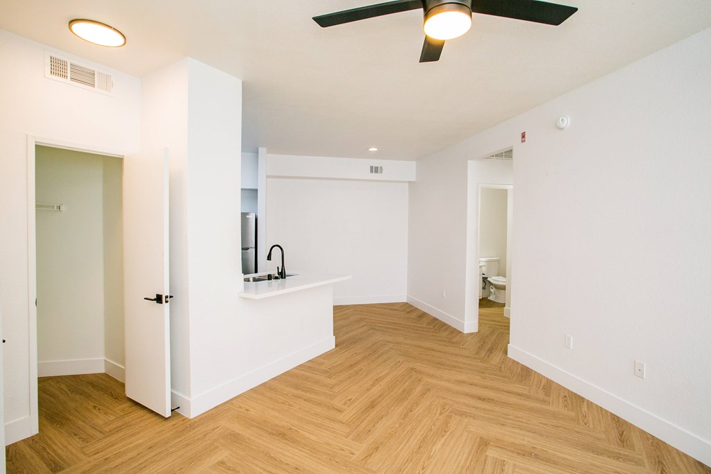 A room with a ceiling fan and a counter with a sink.