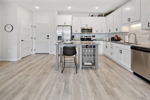 a kitchen with white cabinets and stainless steel appliances