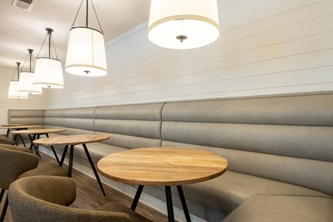 A modern dining area with wooden tables and grey walls.