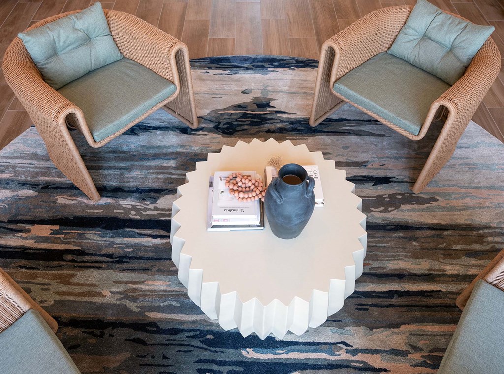a coffee table with two chairs and a vase on it