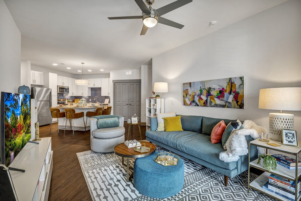 a living room with a blue couch and a ceiling fan