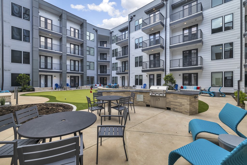 an outdoor patio with tables and chairs at an apartment complex
