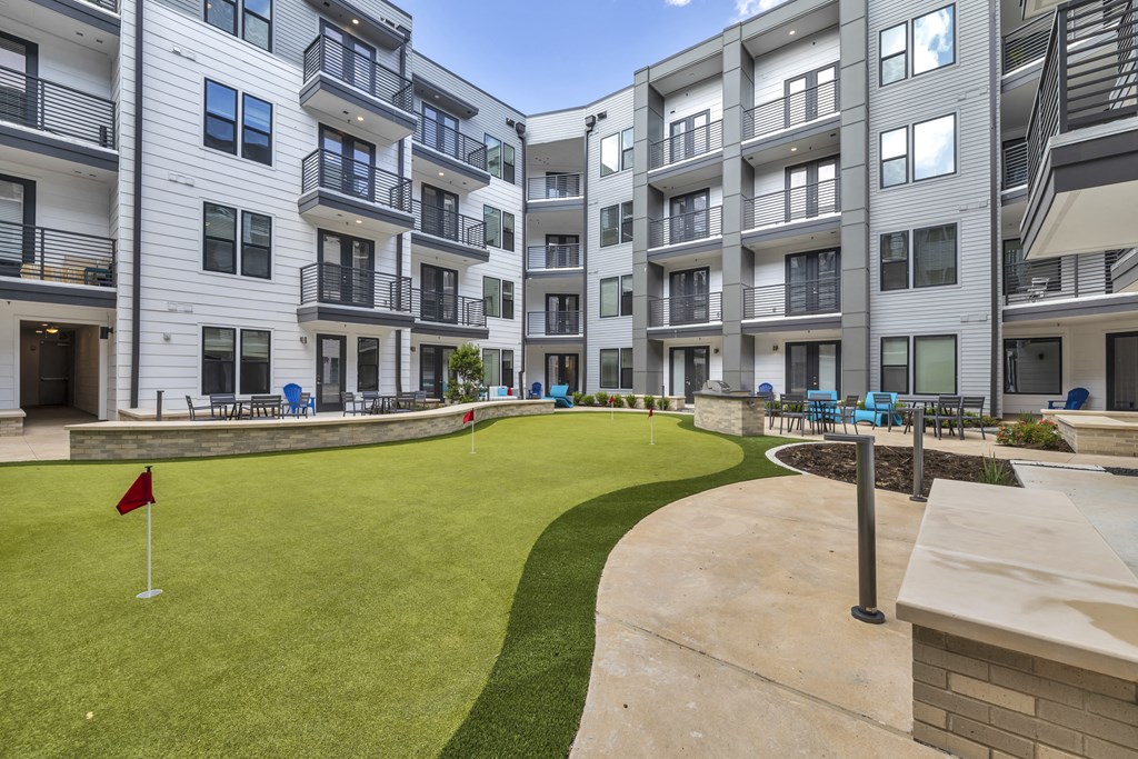 an apartment building with a putting green in the middle of it