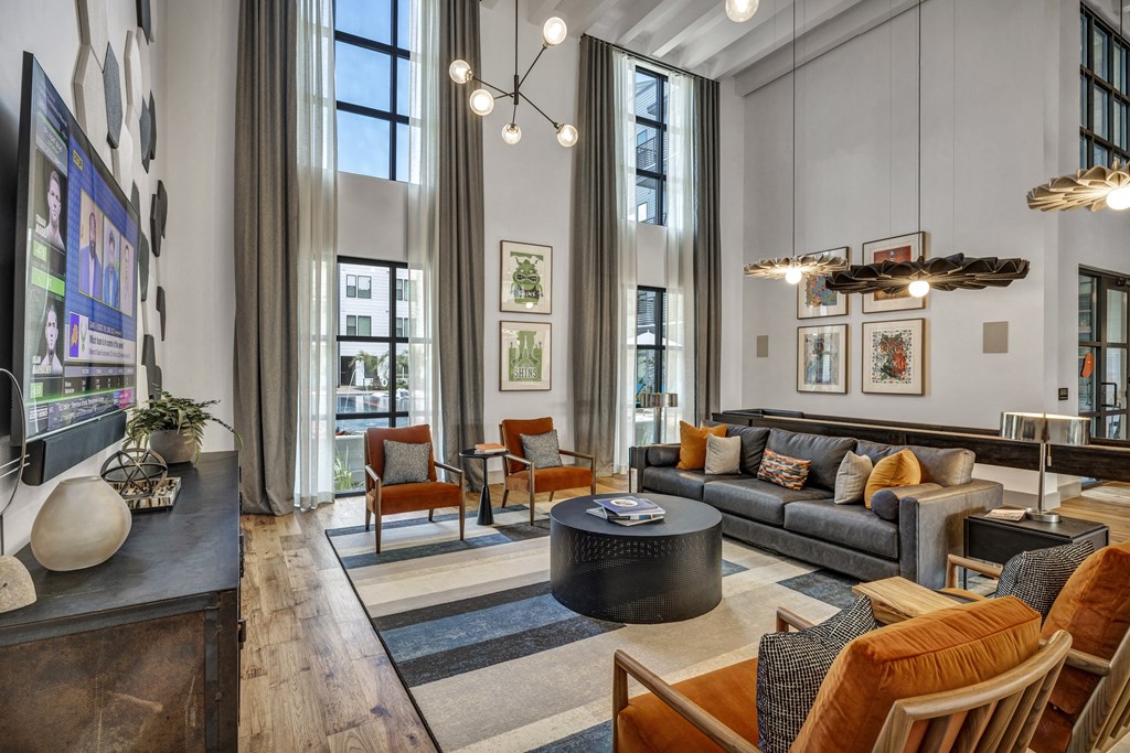 a living room with couches and chairs and large windows