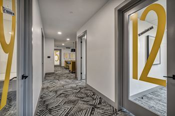 a corridor with doors to rooms and a yellow logo on the wall