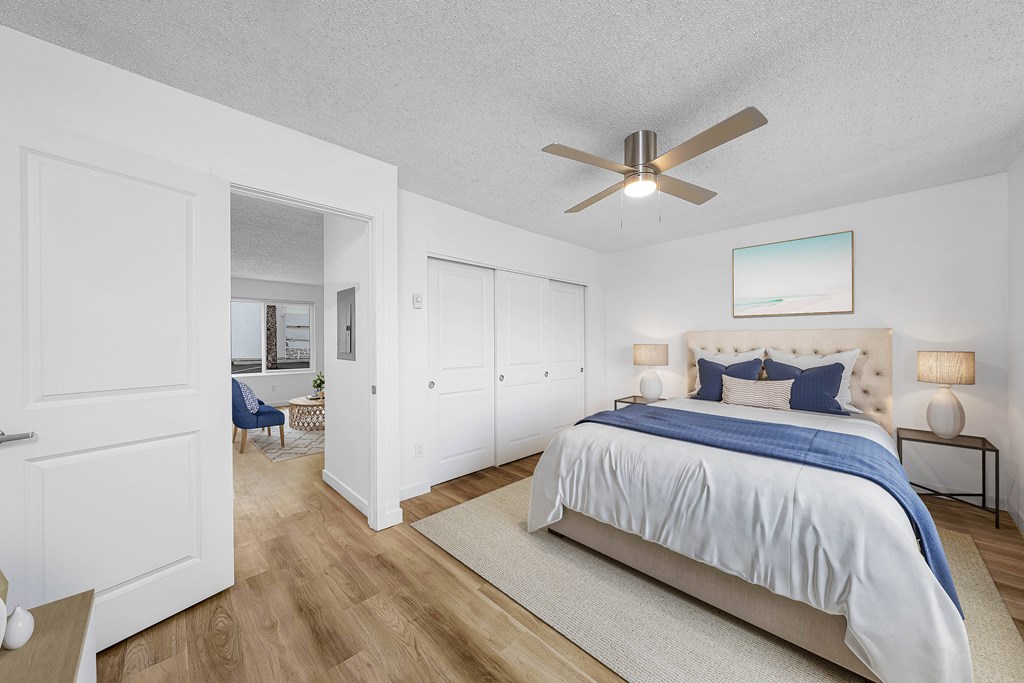 A bedroom with a large bed and a ceiling fan.