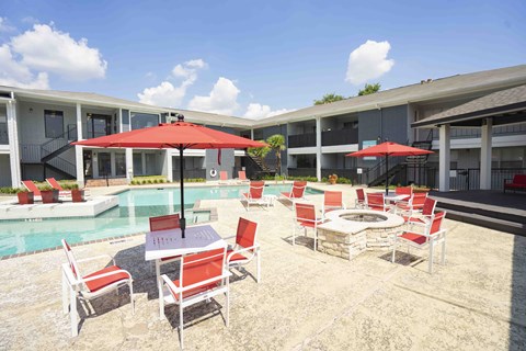 A patio with red cushioned chairs and tables. Una terraza con sillas y mesas con cojines rojos.