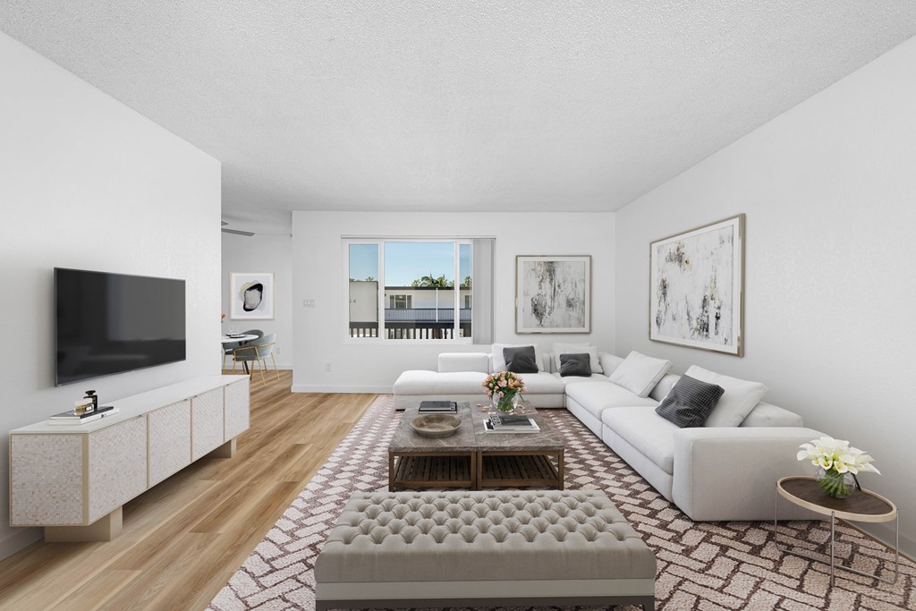 A modern living room with a grey sofa, a wooden coffee table, and a flat-screen TV.