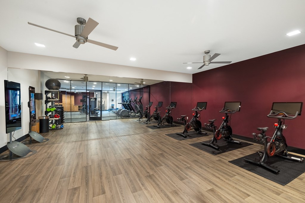 a spacious fitness room with treadmills and exercise bikes
