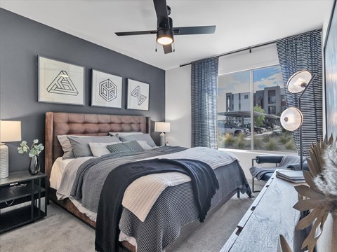 A bedroom with a large bed and a ceiling fan.