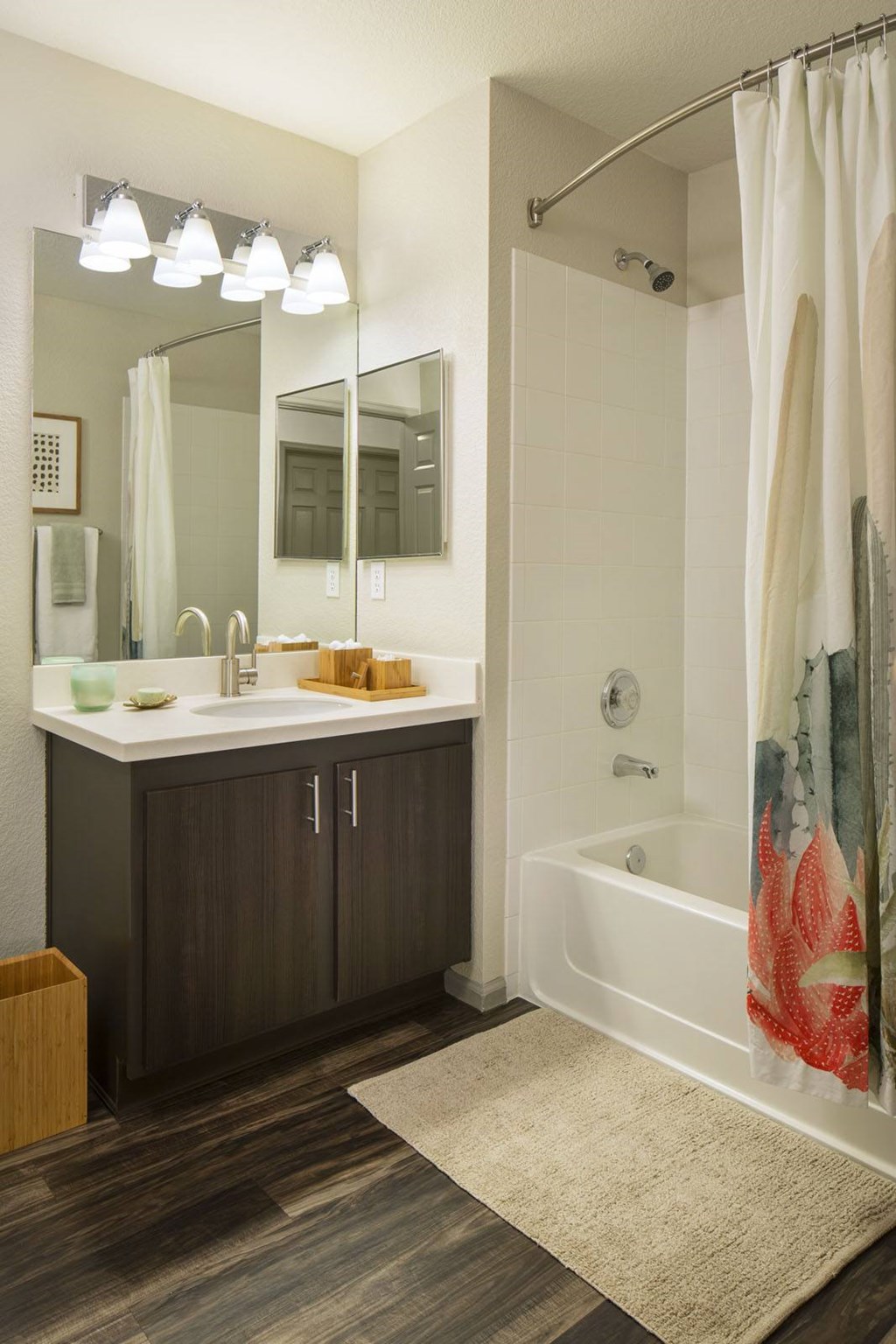 A bathroom with a white tub and a large mirror.