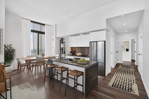 A modern kitchen with a dining table and chairs.