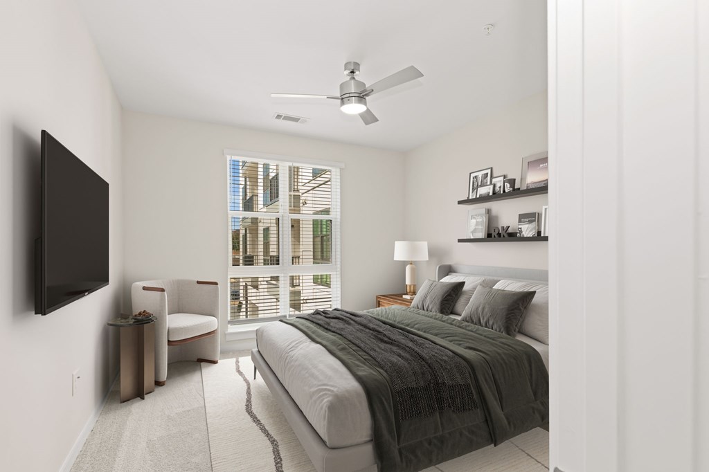 A bedroom with a large bed and a flat screen TV mounted on the wall.
