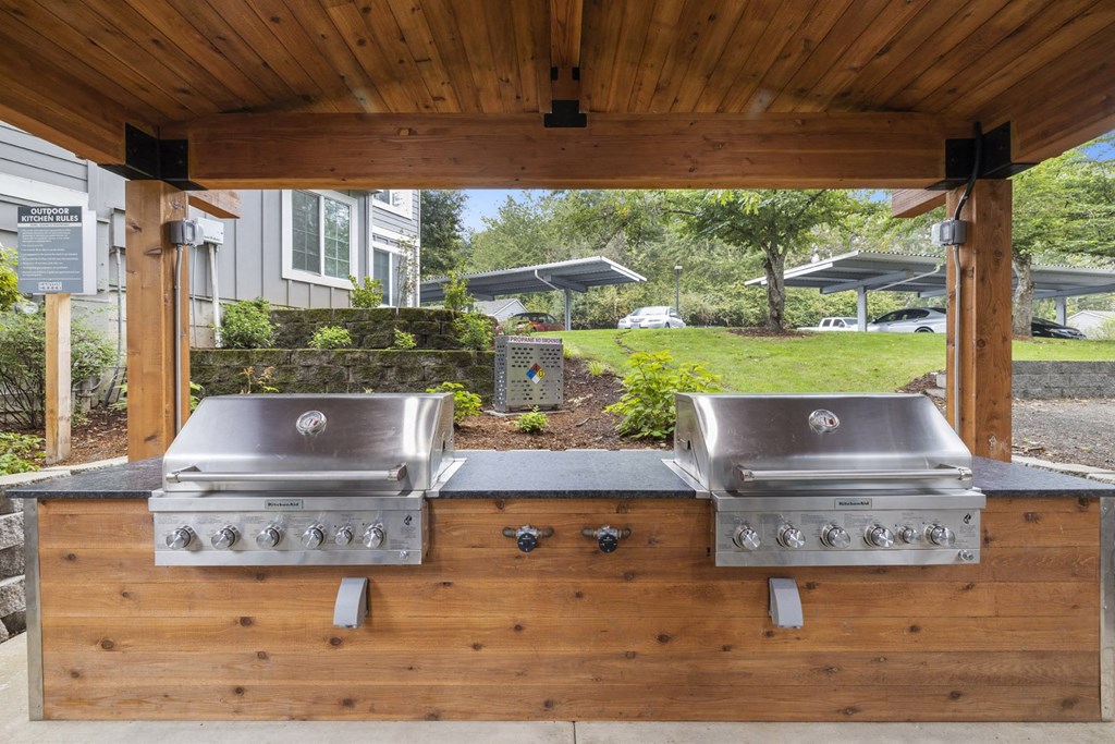 a covered outdoor grill area with two stainless steel appliances