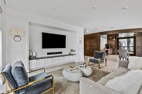 A modern living room with a grey sofa, a black chair and a white coffee table.
