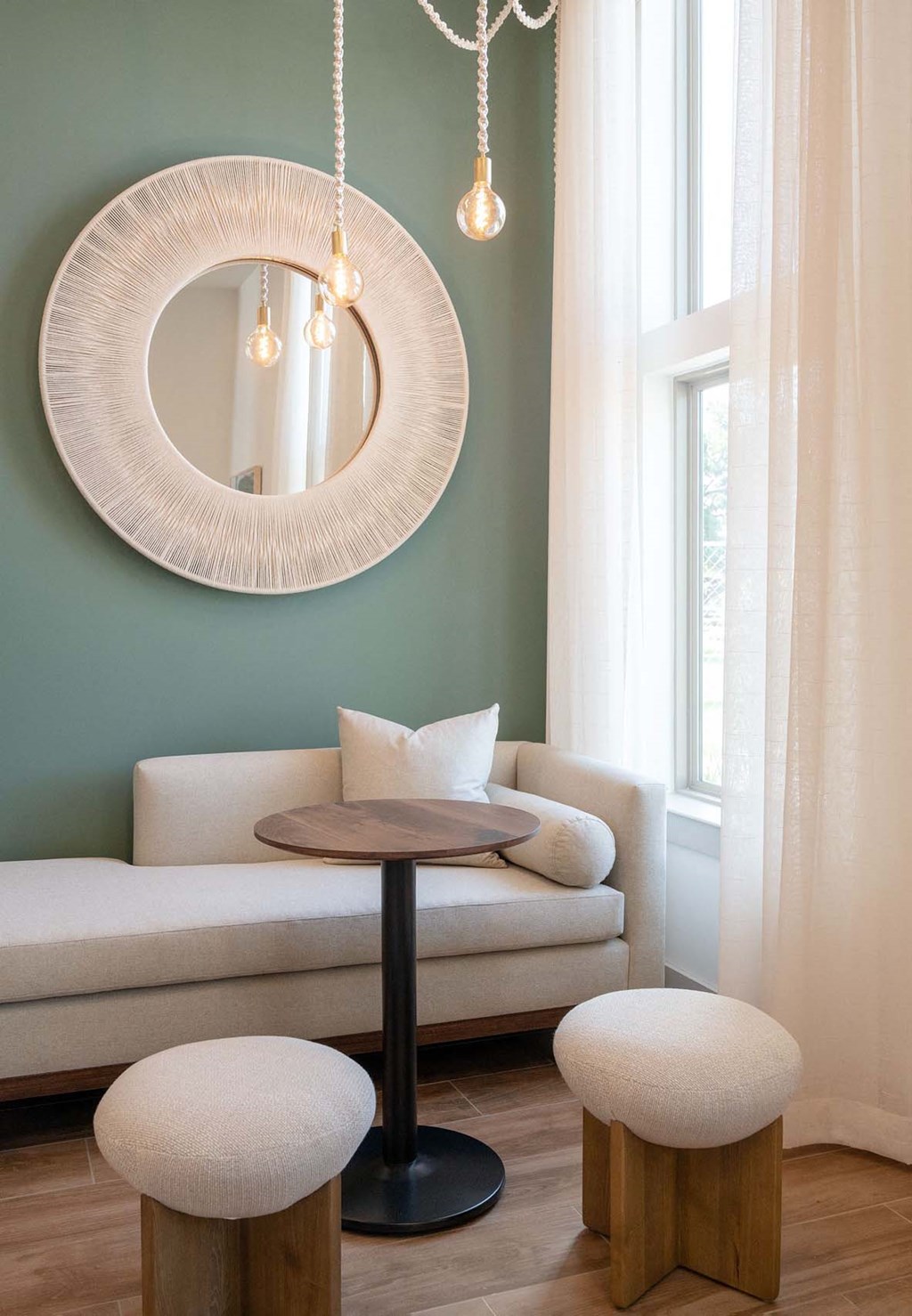 a living room with a round table and a mirror