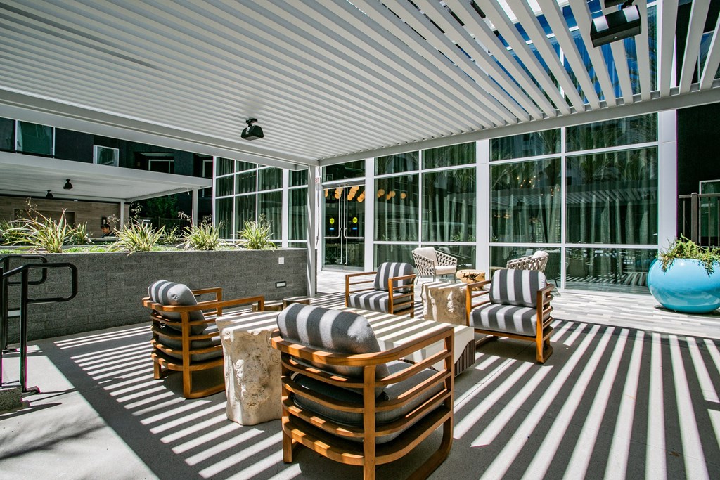 a patio with chairs and a table under an awning