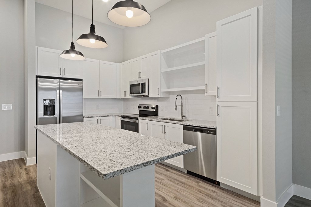 a kitchen with white cabinetry and an island with a granite countertop