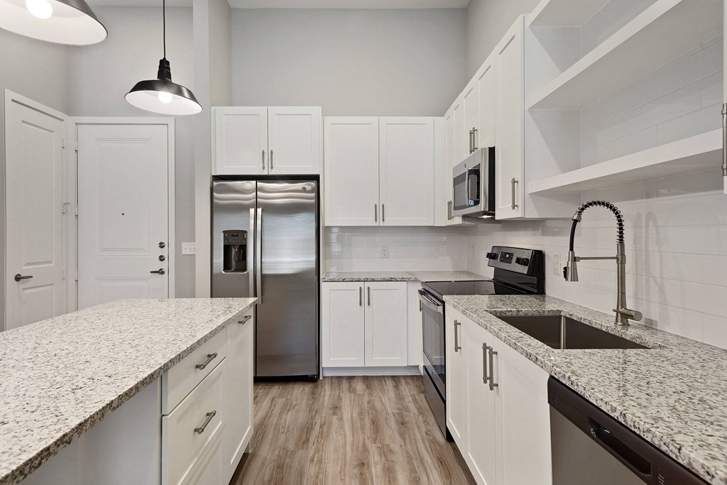 a kitchen with white cabinets and granite countertops
