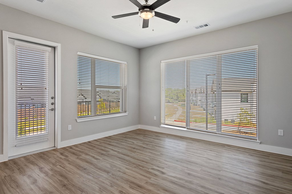 a bedroom with two windows and a ceiling fan