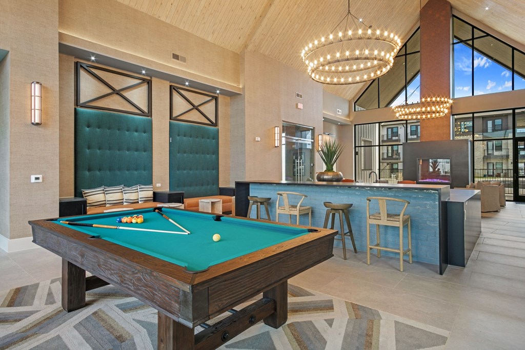 a pool table in a clubhouse with a bar