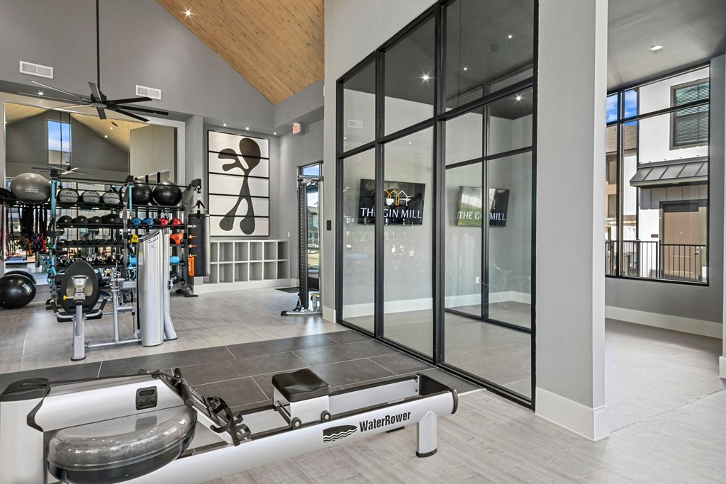a home gym with glass doors and a weights rack