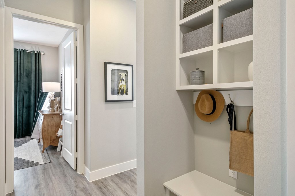 a renovated living room with shelves and a door to a bedroom