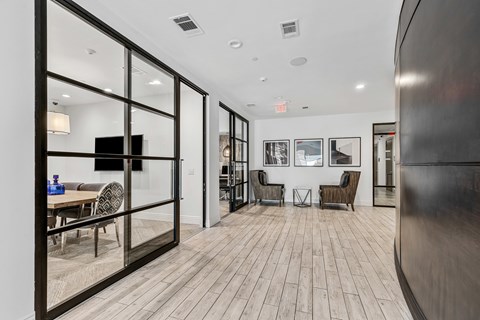 A modern living room with a wooden floor and glass walls.