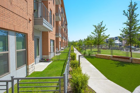a view of the side of a building with a sidewalk and grass