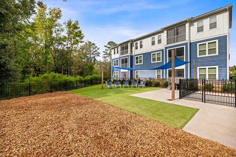 A blue and white apartment building with a playground in front.